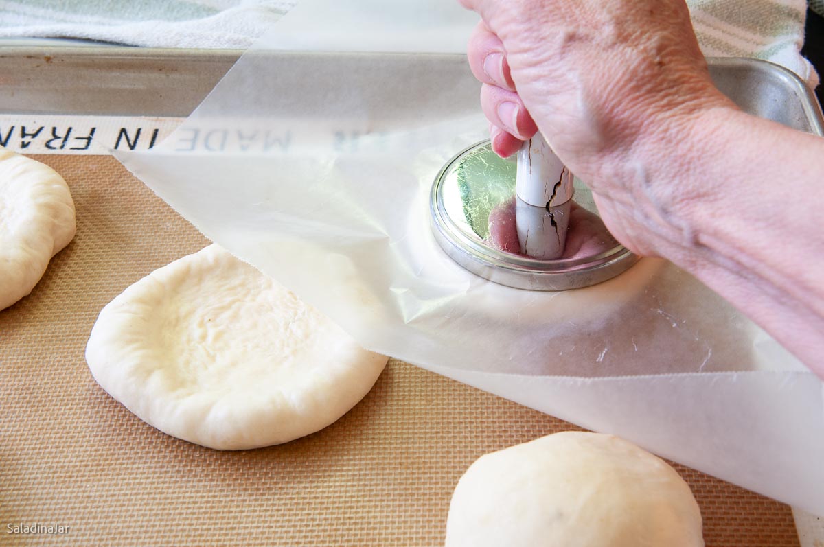 flattening the balls with wax paper and a tool for flattening meat.