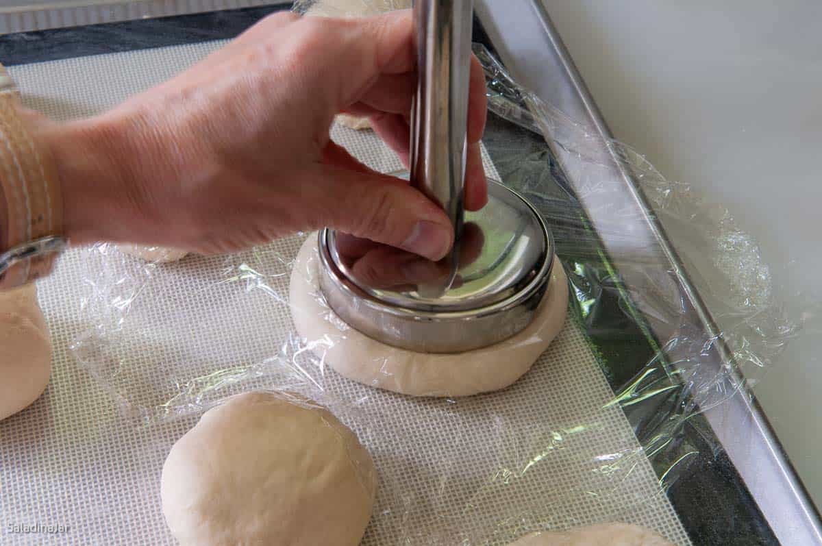 Using a meat flattener to flatten rolls.