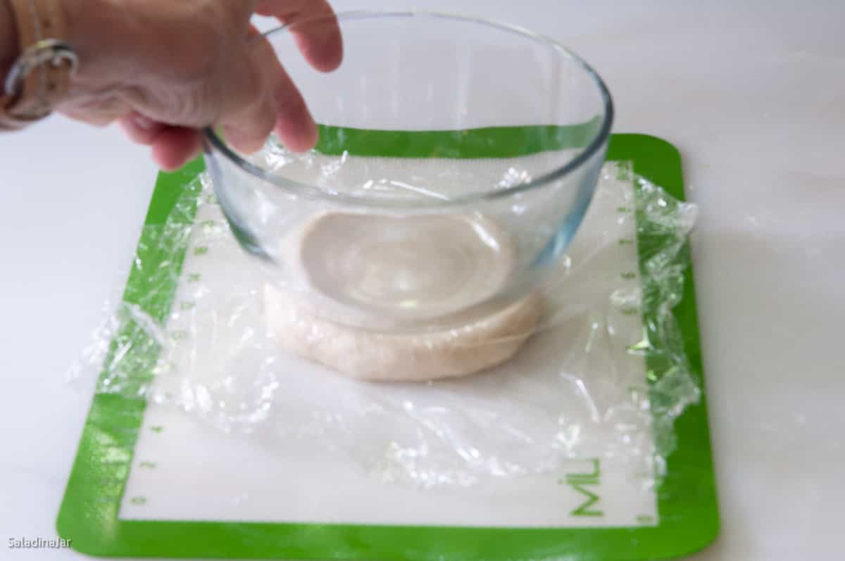 Using a clear bowl and plastic wrap to flatten rolls.