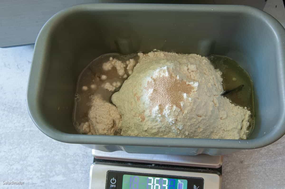 DOUGH ingredients inside bread pan that is sitting on a digital scale