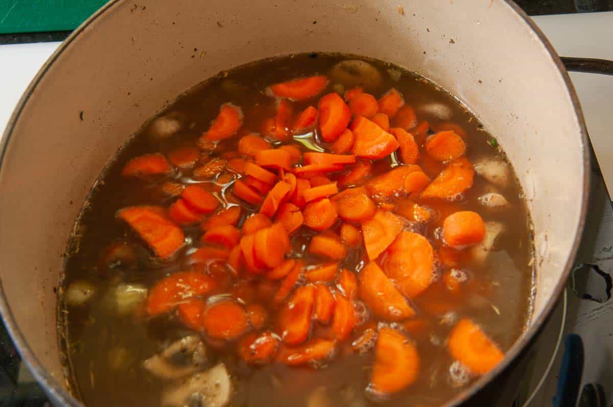 adding carrots to the pot.