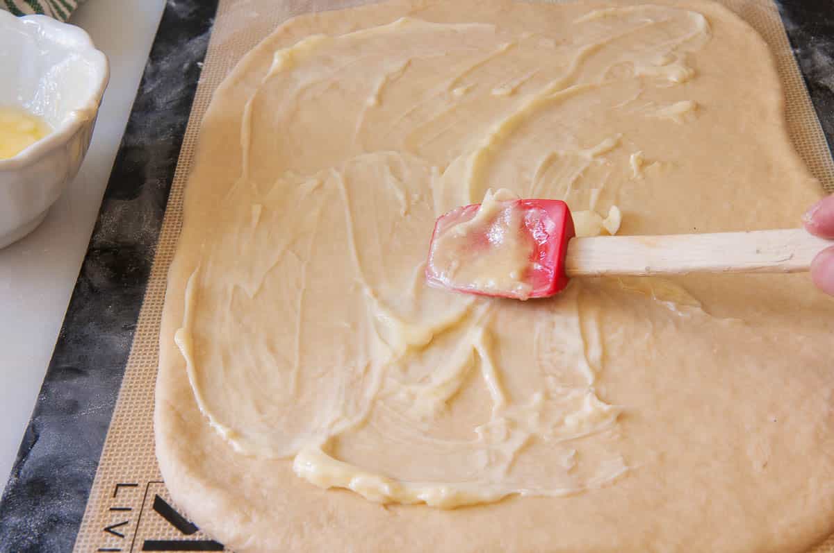 spreading butter over the rectangle of dough