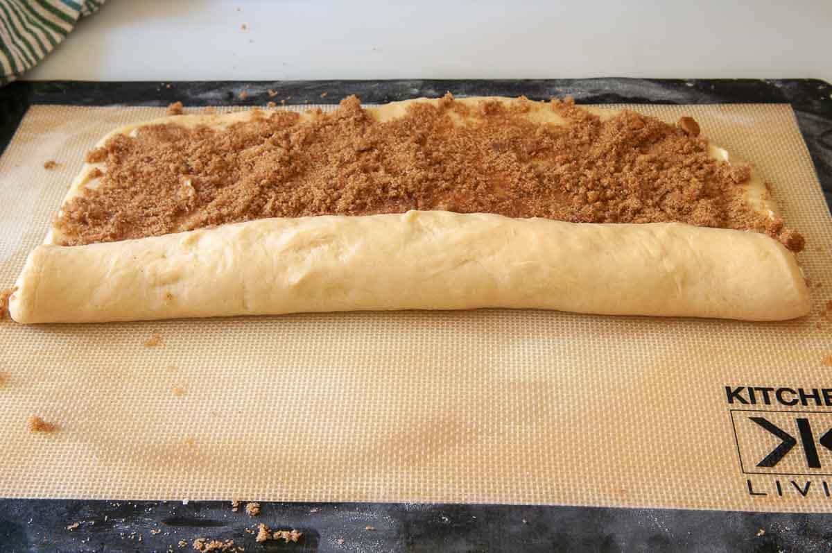 rolling up dough with the filling inside.