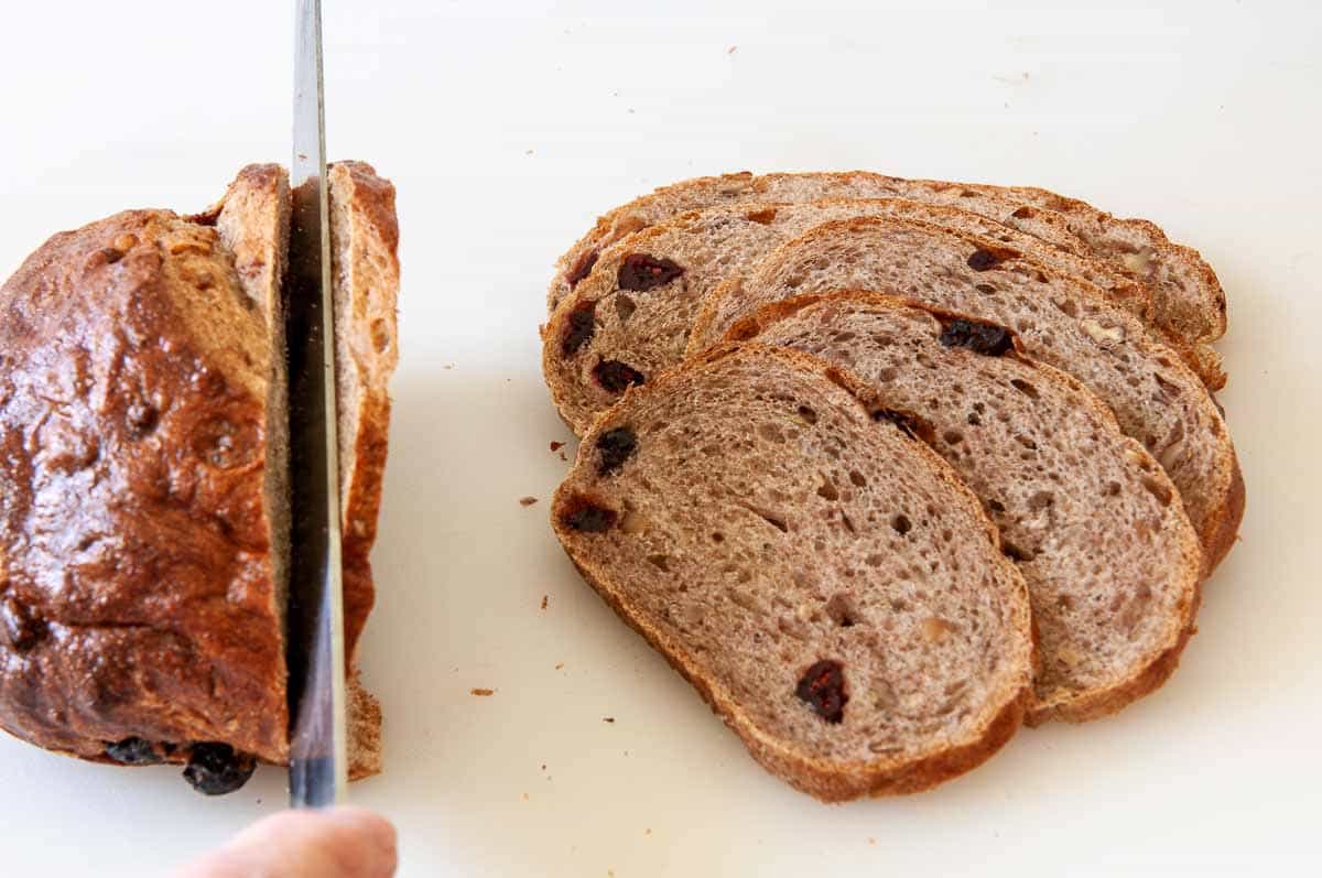 Slicing stale bread with a sharp serrated knife to make melba toasts