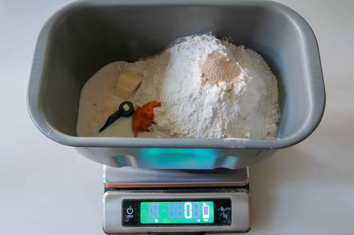weighing the ingredients into a bread machine pan with digital scales.