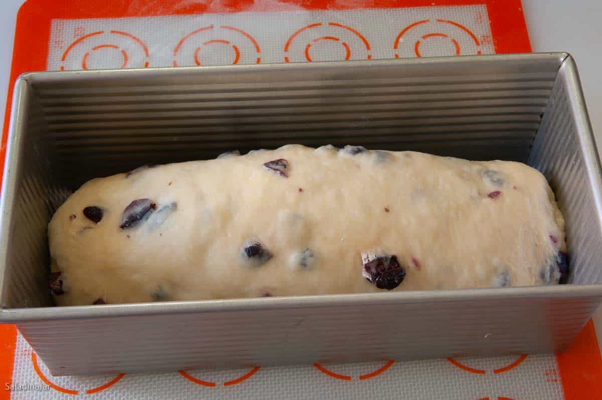 placing the shaped dough into a loaf pan.