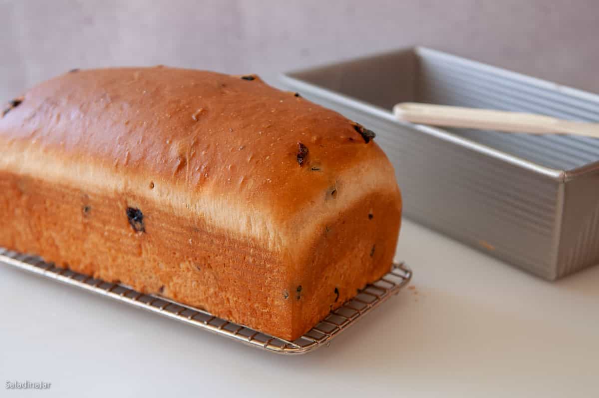 Bread sitting on a cooling rack before slicing or storing.