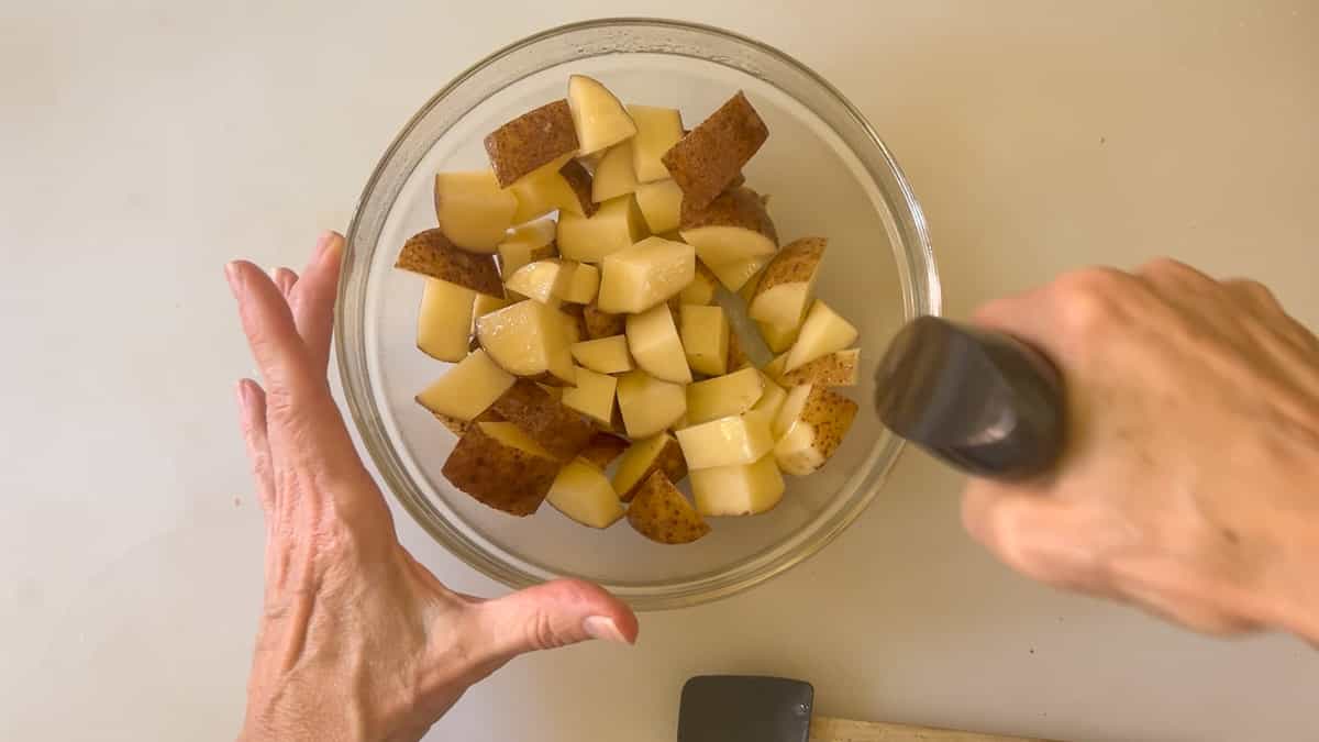 spraying cut potatoes before baking