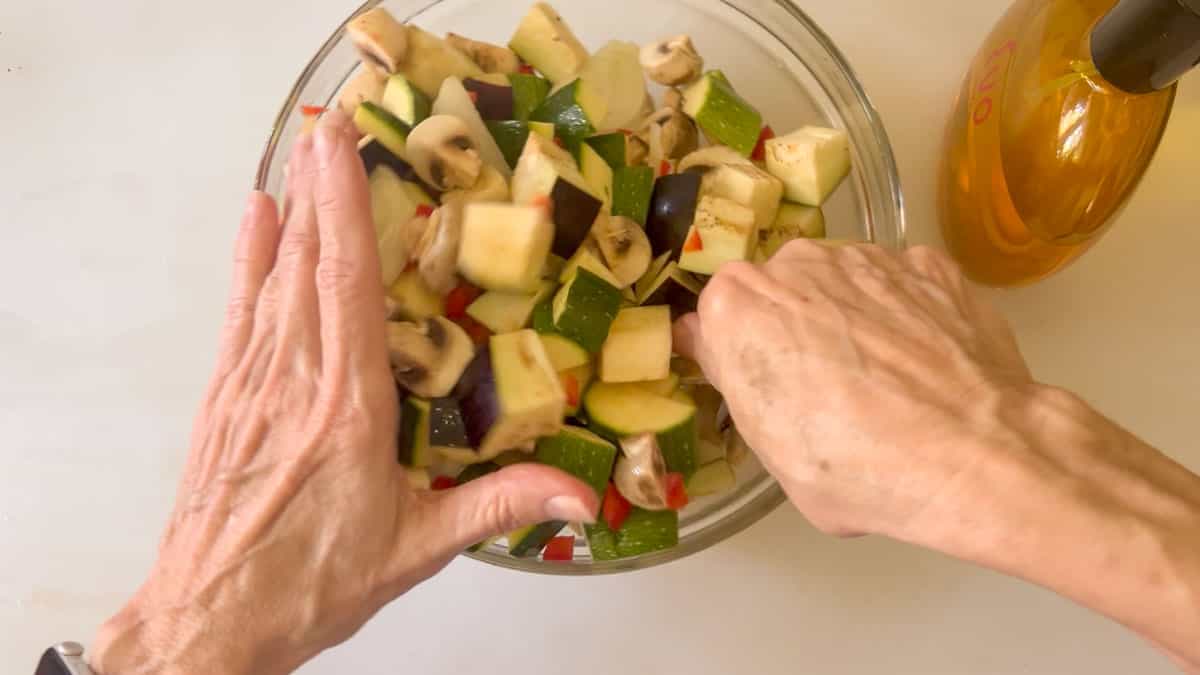 mixing oil into the remaining vegetables.