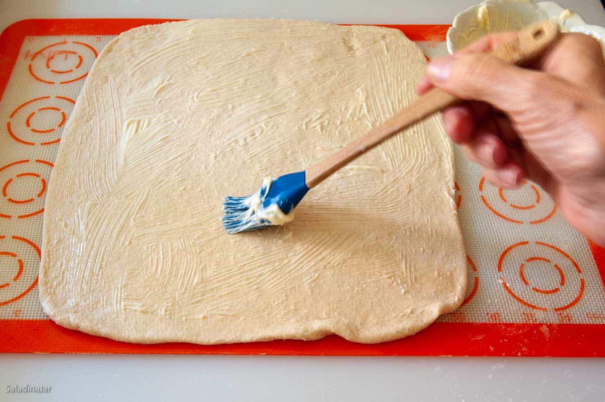 Brushing the dough with butter.