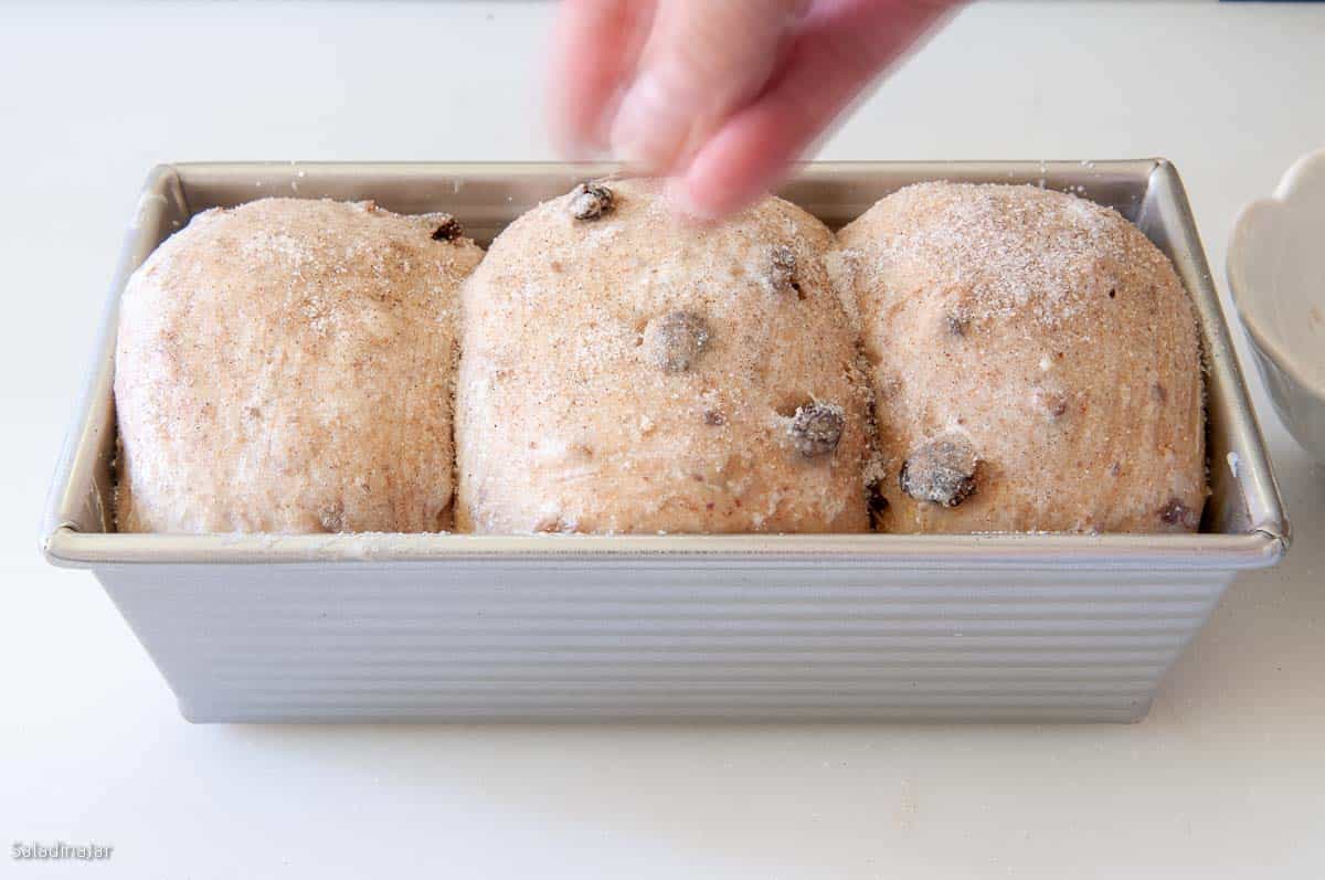 Quickly sprinkle the cardamom and sugar mixture over the top of the bread.