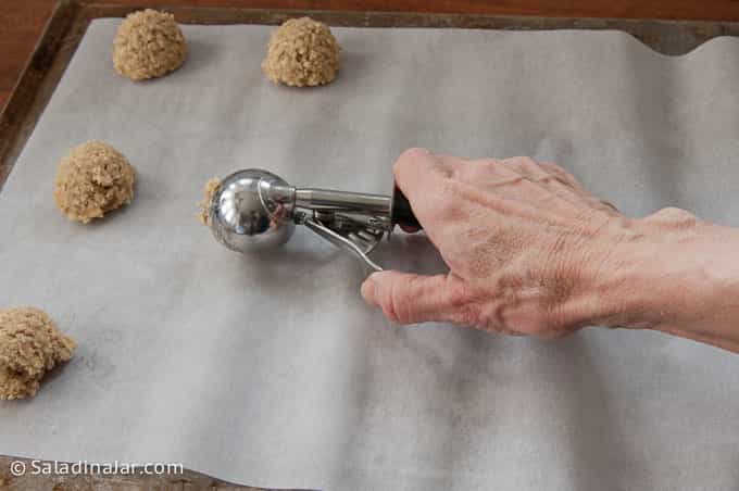 Using a cookie scoop to make cookies.