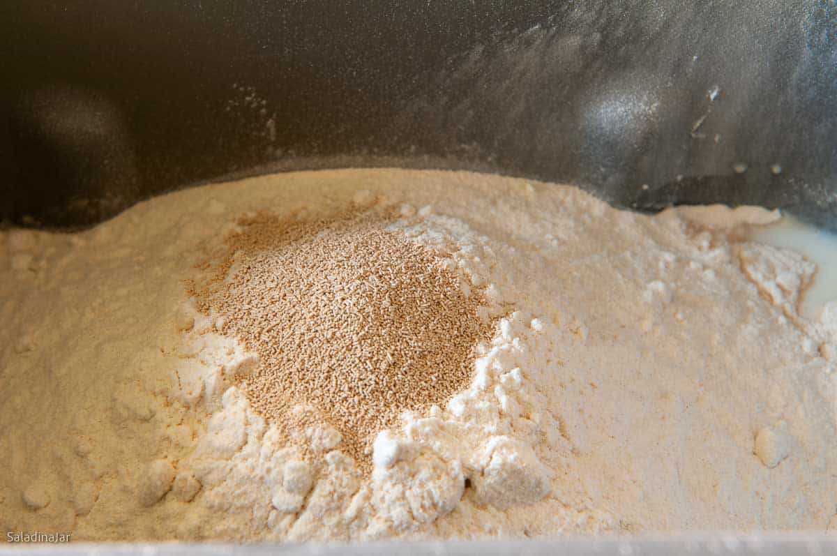 adding all the ingredients to the bread machine pan at the beginning.