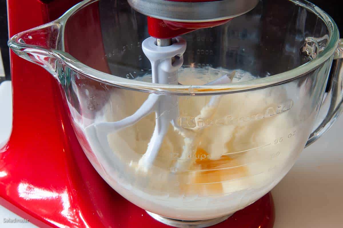 adding the egg yolk and vanilla to the creamed butter and sugar.