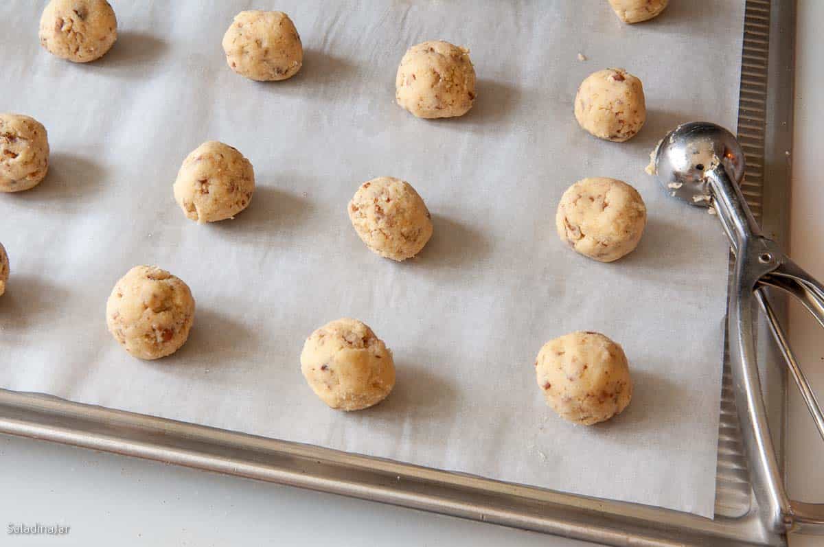 Using a spring loaded dipper to make balls out of cookie dough.