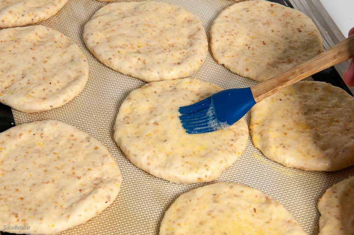 mashing dough balls the second time and glazing with egg glaze