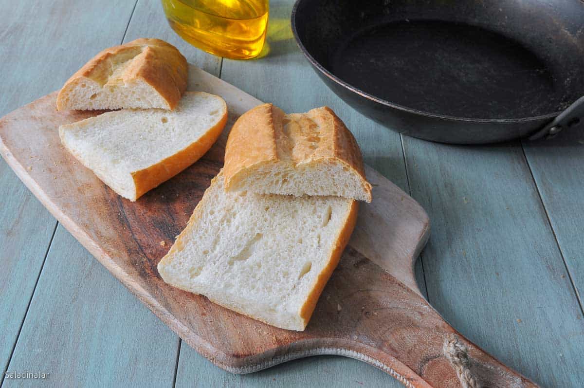 bread sliced for sandwiches next to carbon steel skillet.