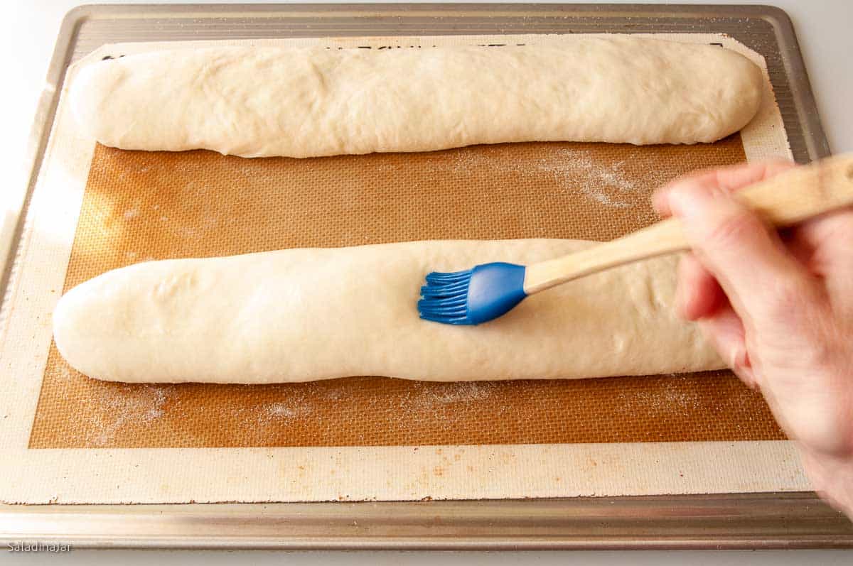 Brushing dough with glaze before baking. 