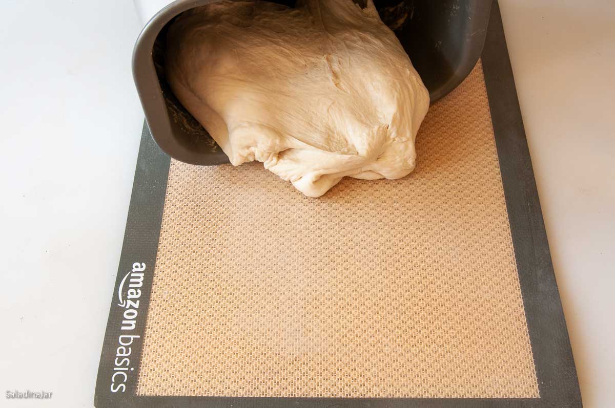 pulling the dough out of the bread machine pan.