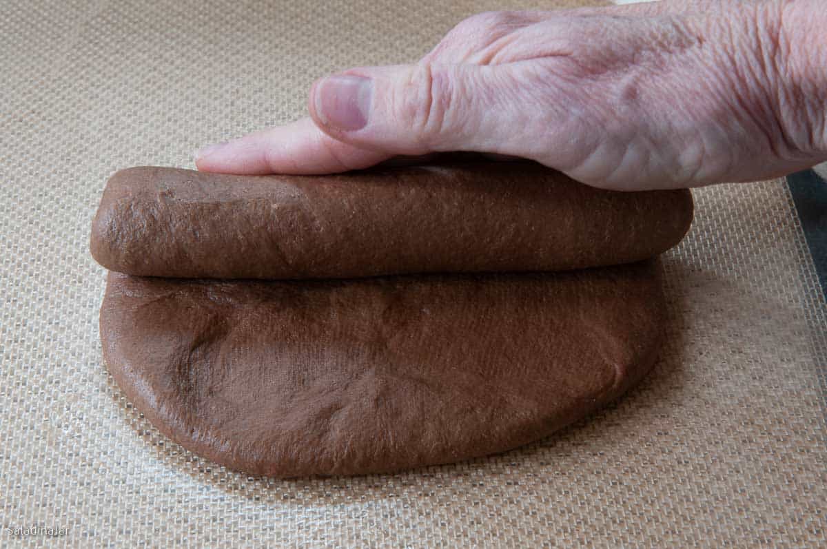 Rolling dough into a cylinder.