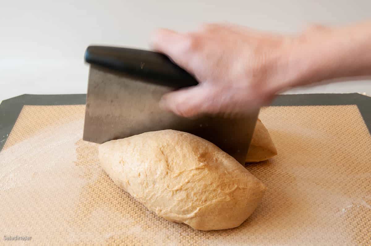 divide the dough in half with dough scraper.