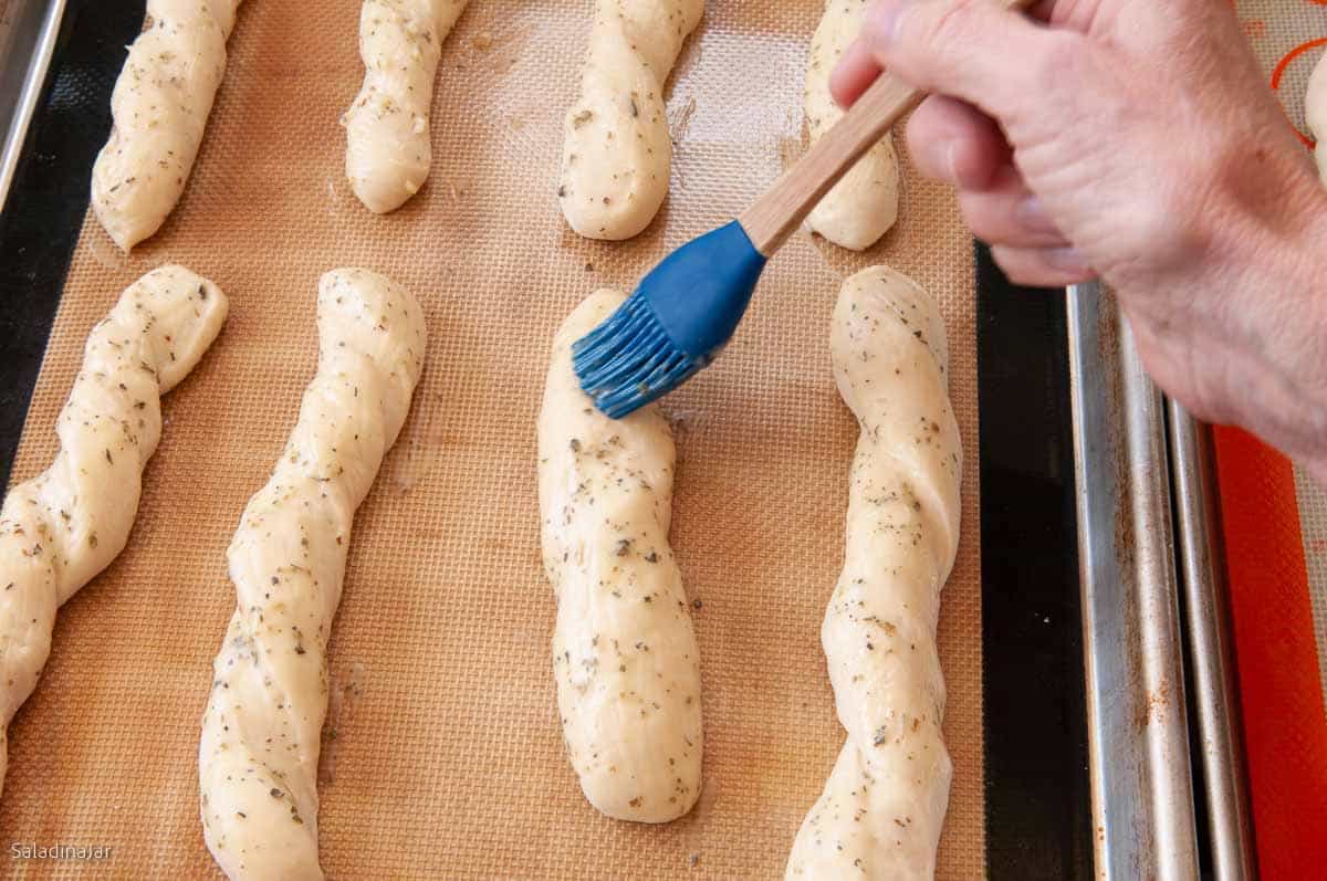 brushing the bread sticks with buttery glaze.