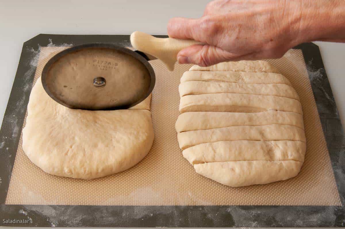 cutting the bread sticks with a pizze cutter.