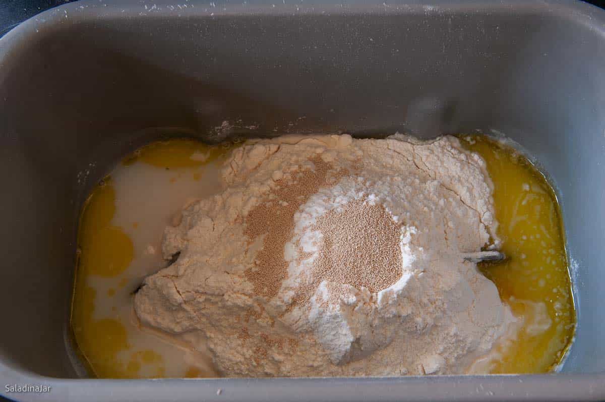 all ingredients for the dough are added to the bread maker pan.