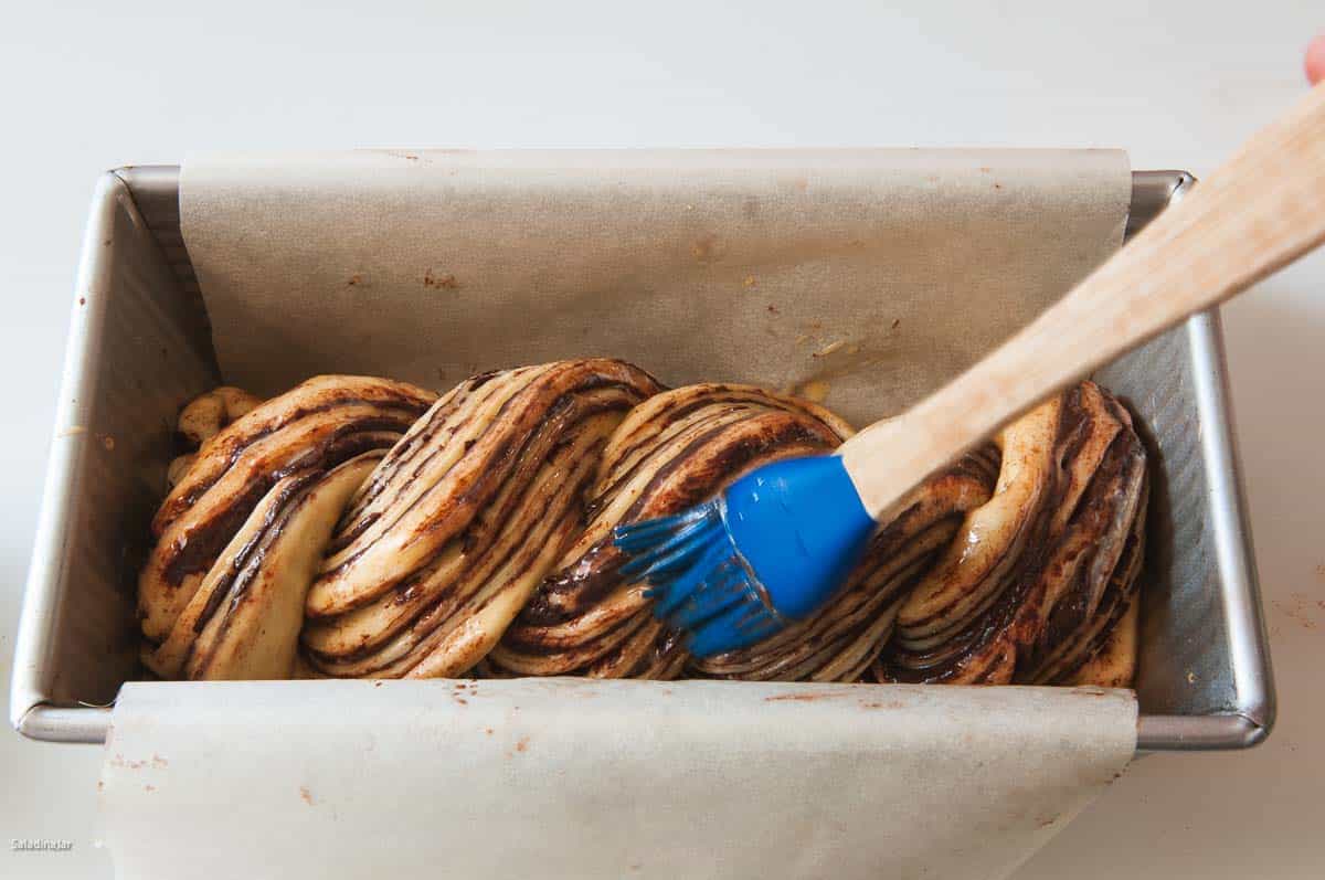 Brushing with glaze before baking.