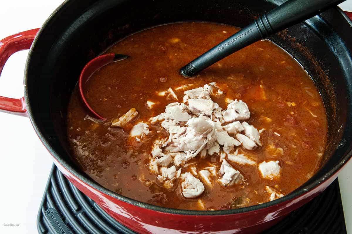 adding chicken to the soup.