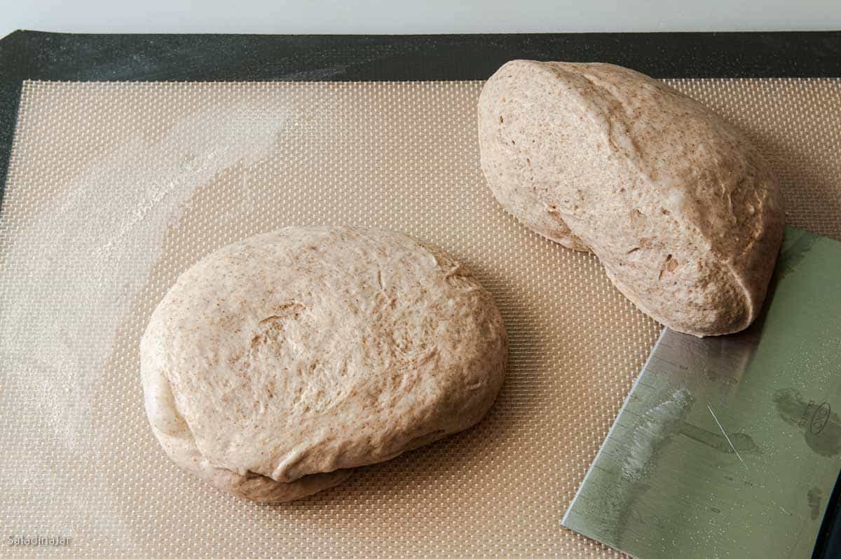 dough divided in half. one half is shaped into a round patty.