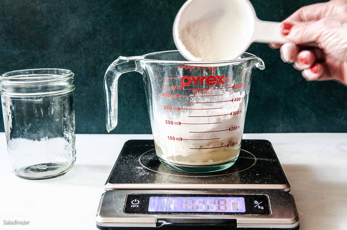 Adding the flour to the starter using a  digital scale.