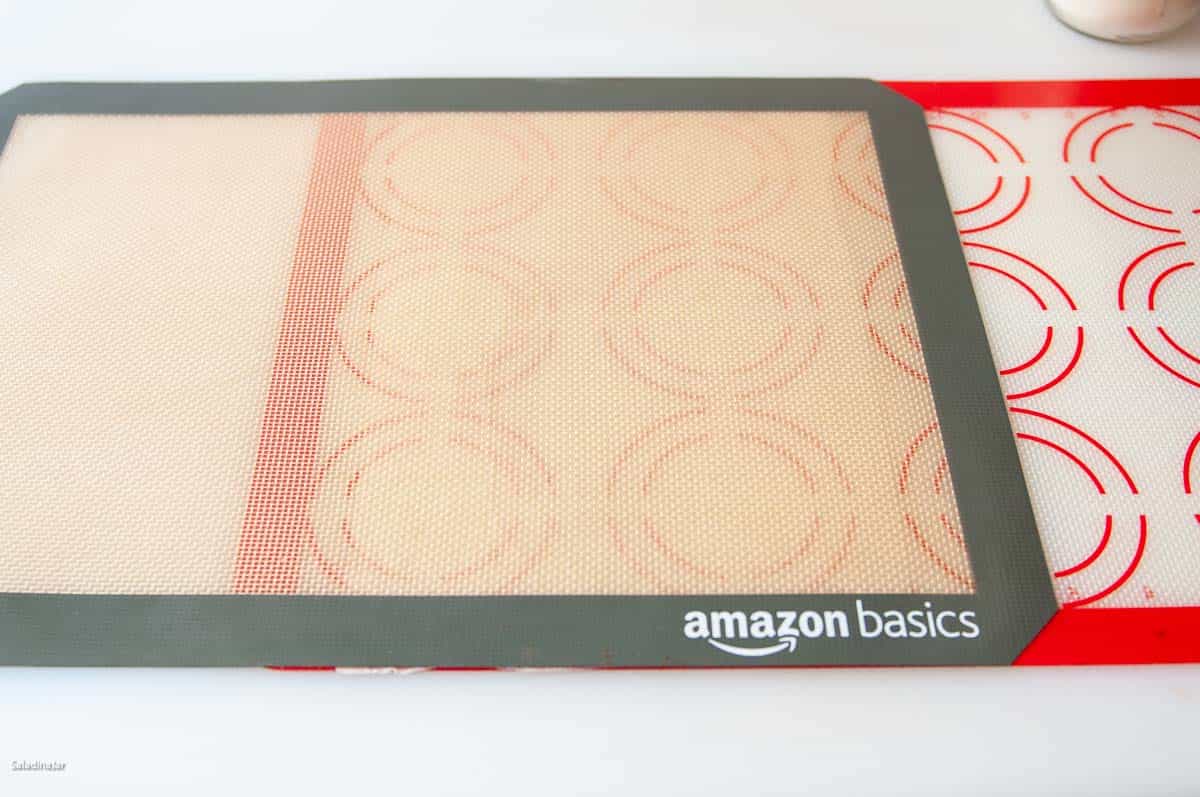 using two silicone mats to roll long rectangle of dough.