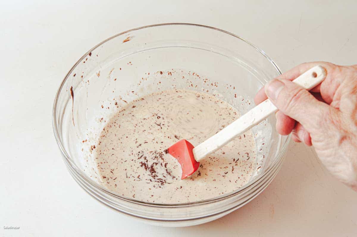 Stirring the melted chocolate into the cream.