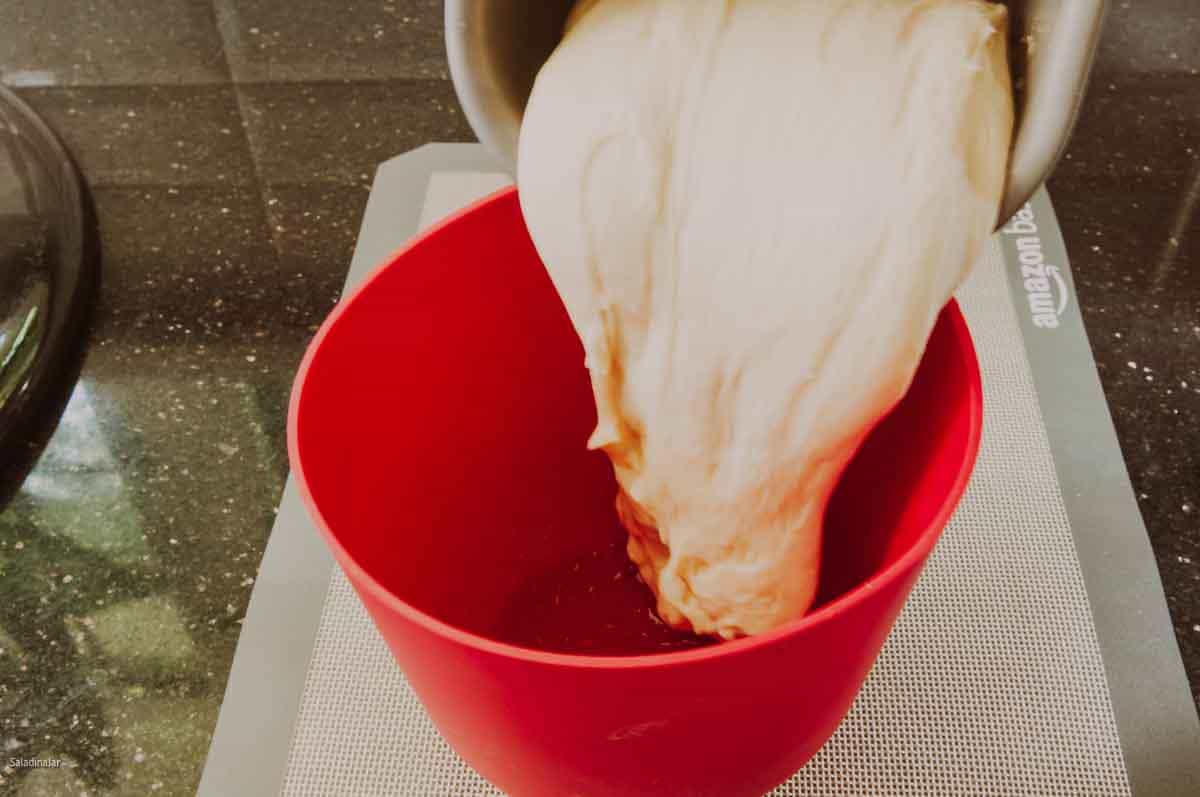 Removing the dough from the bread machine pan before chilling it.