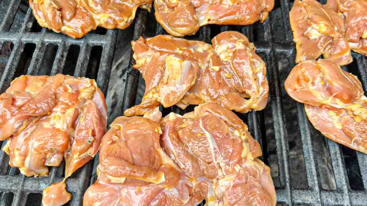 chicken thighs on a hot grill with the smooth side down.