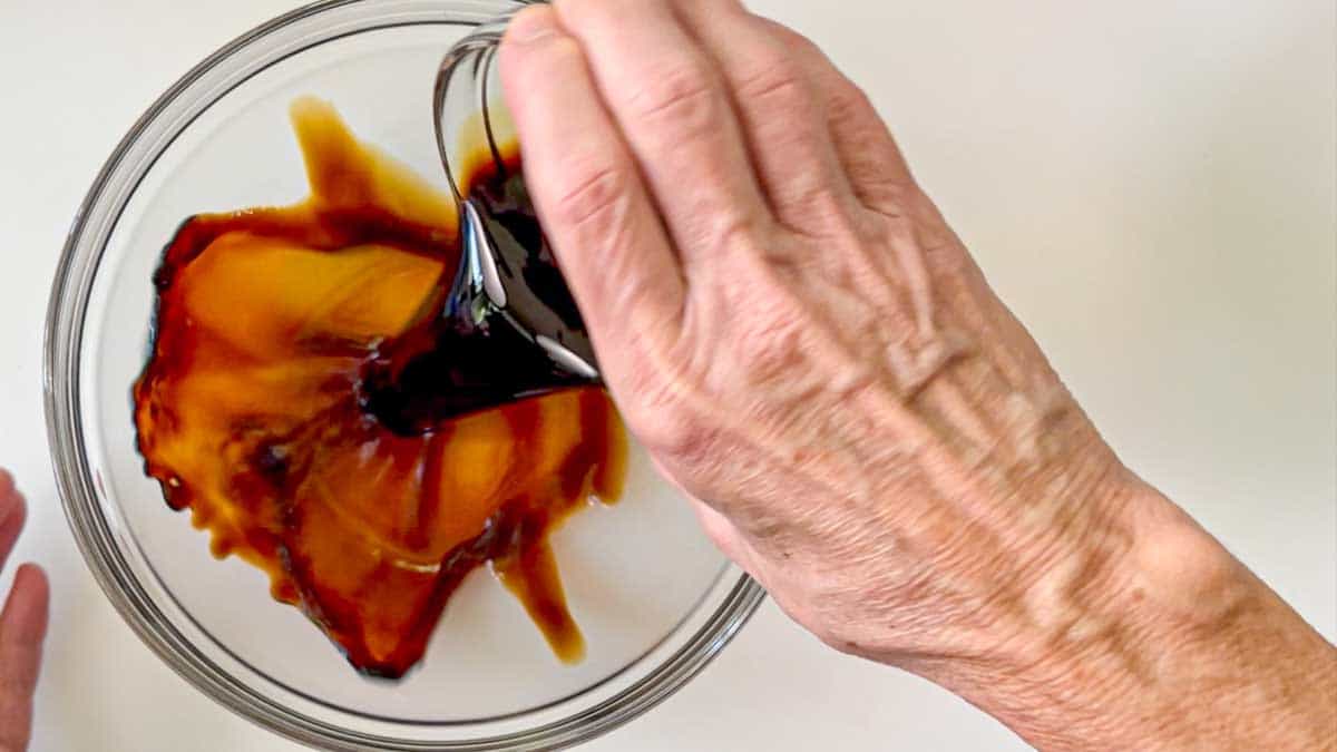 pouring soy sauce into a medium bowl.