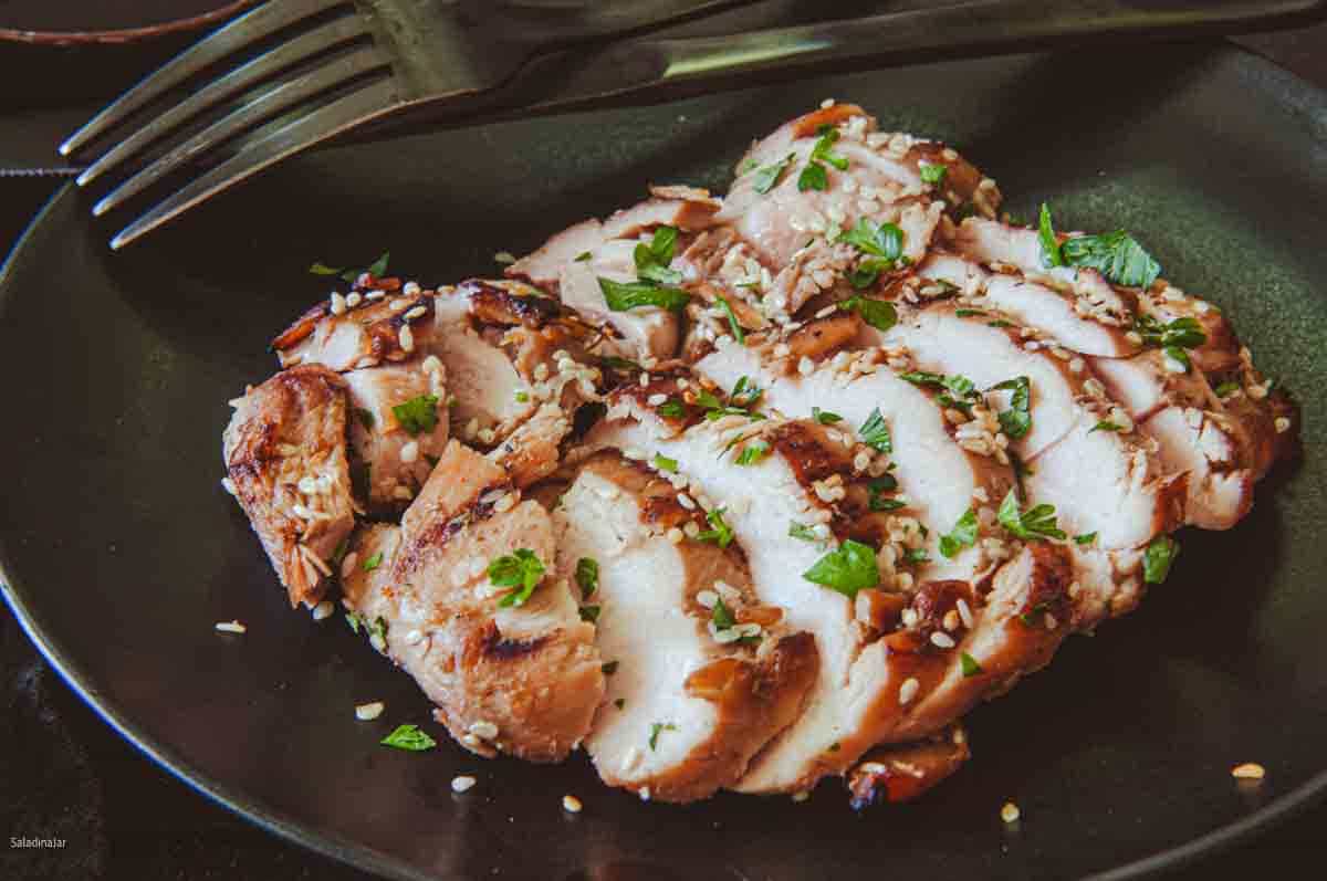 sliced teriyaki chicken thighs on a plate--ready to eat.