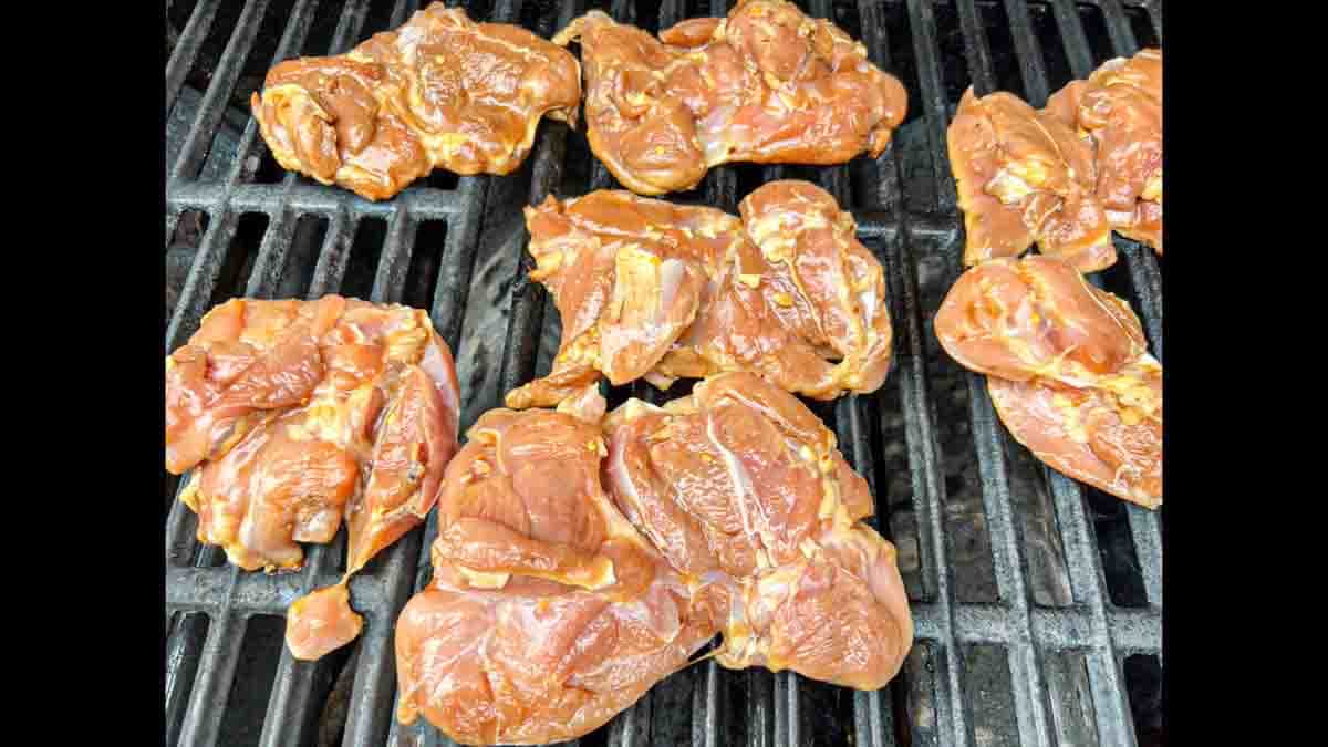 Laying thighs on the grill with the smooth side down.
