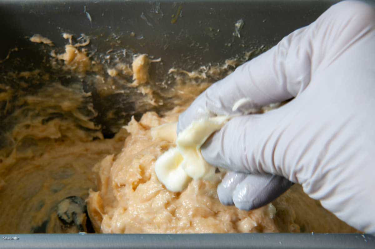 using fingers to squeeze pliable butter into the dough as it mixes.