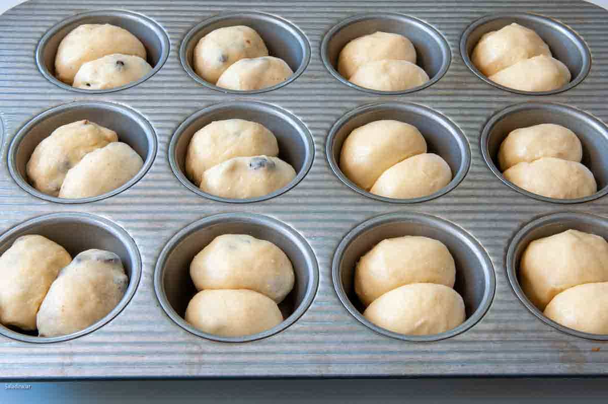 Rolls placed in a muffin tin, ready for the final proofing stage.