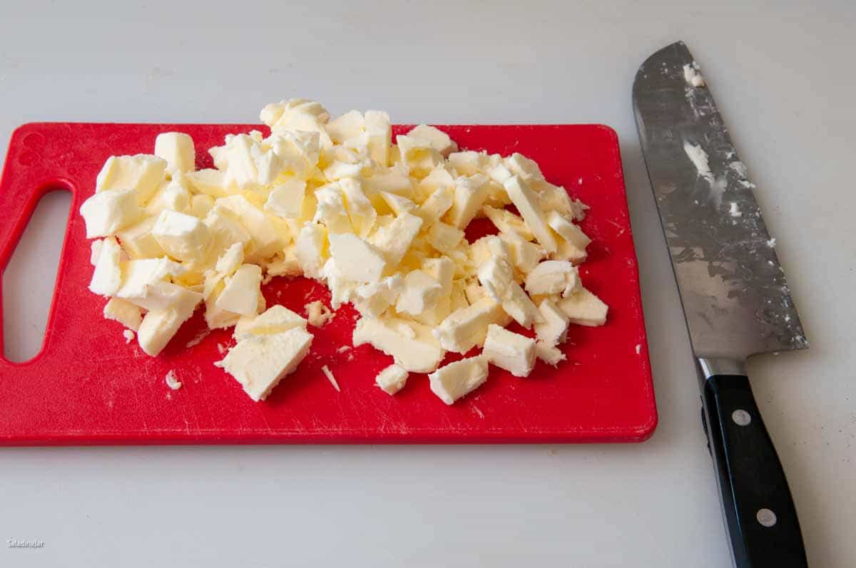 Chopping cold butter before adding it to the dough.
