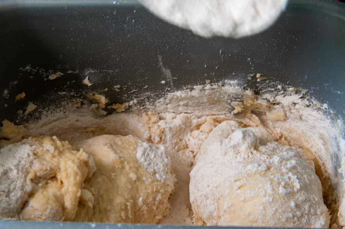 adding the remaining flour to the sticky dough