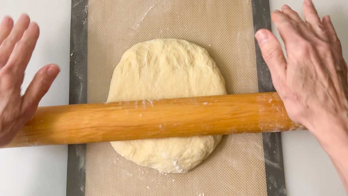 Using a rolling pin to shape the dough into a rectangle.
