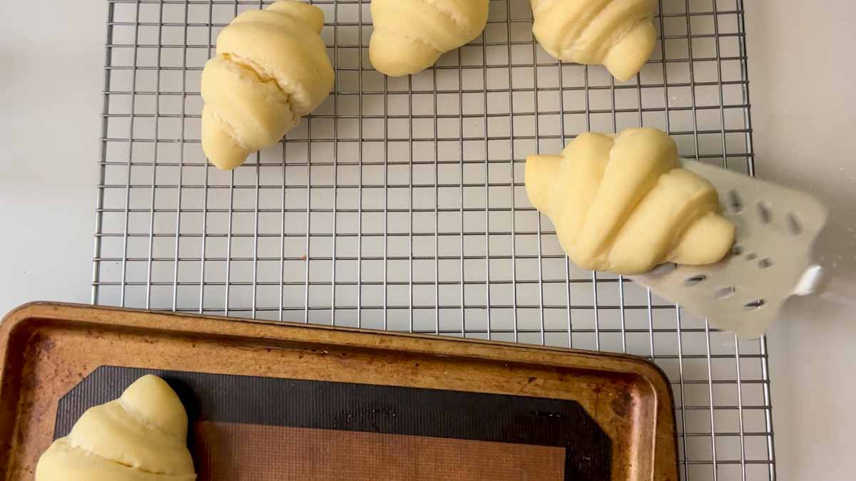 Removing the rolls with a spatula to a cooling rack.