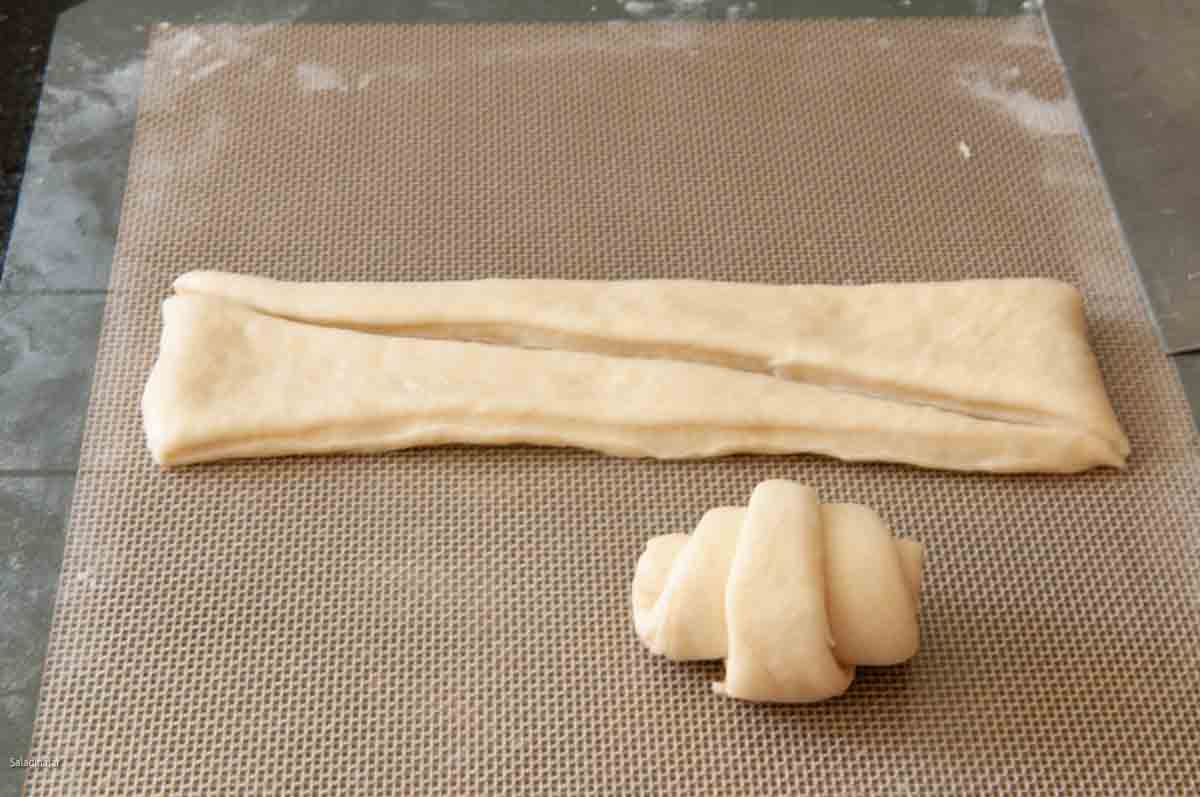 Rolling up the triangles of dough to make a butterhorn roll.