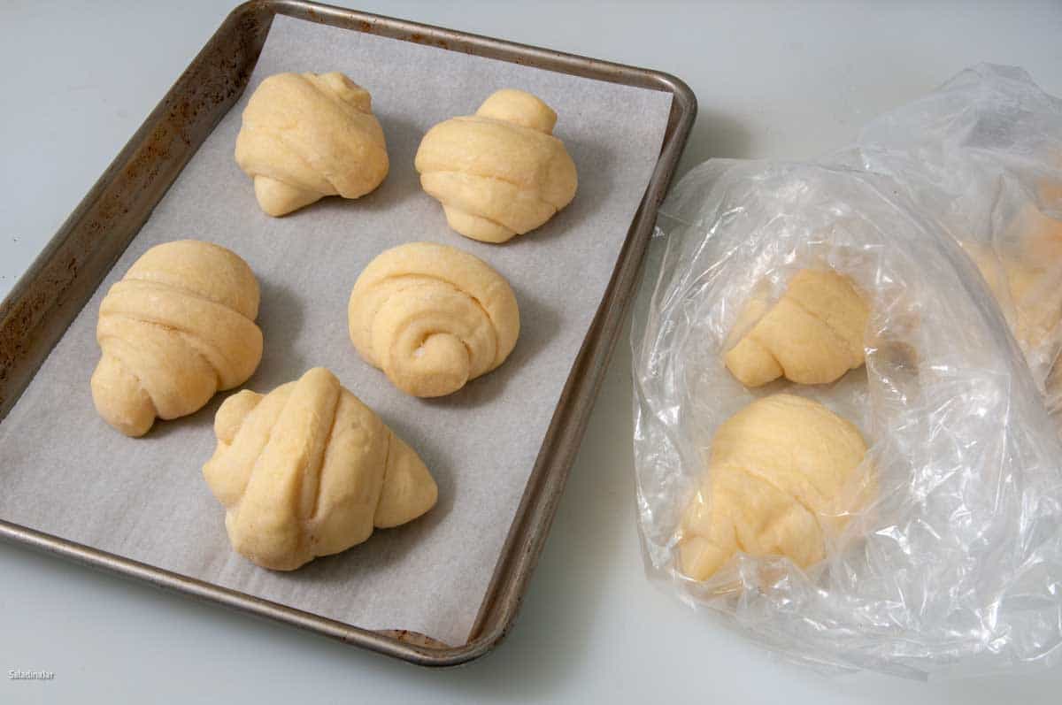 Baked butterhorn roll with butter on a butter knife to the side.