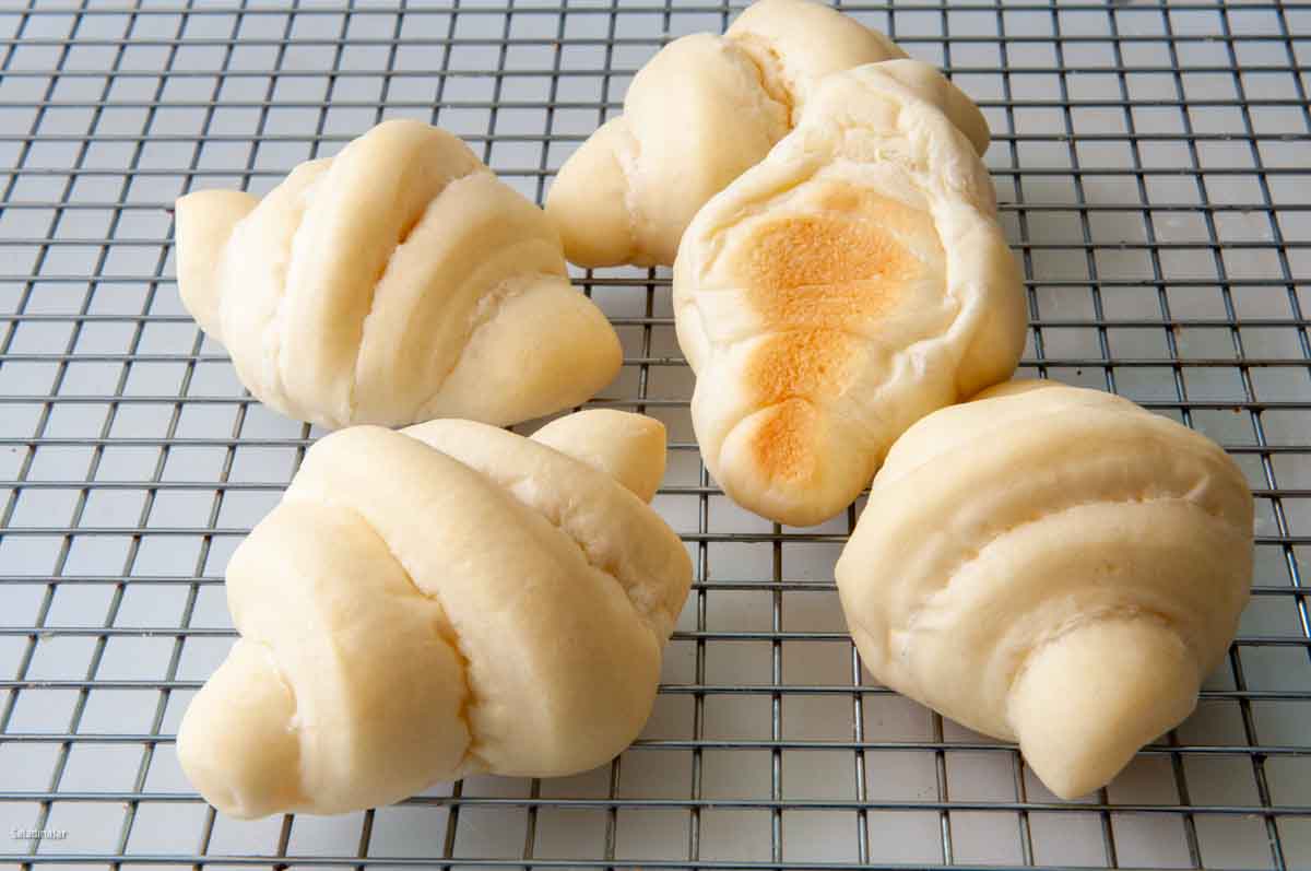 Par-baked brown-and-serve rolls on a cooling rack.