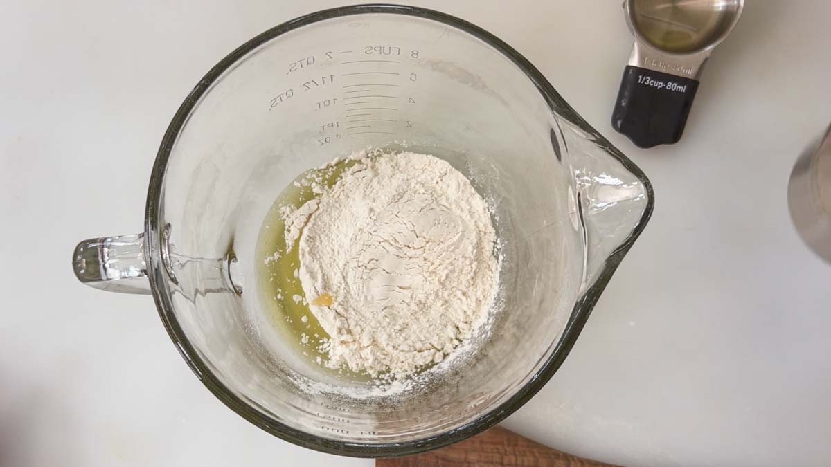 Adding the oil and flour to a 2-qt Pyrex bowl.