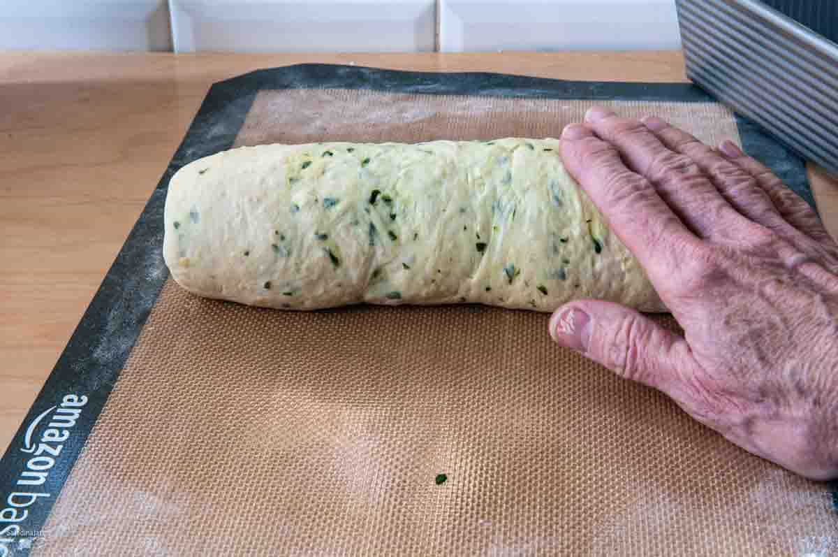 Rolling the dough with hands starting from the short edge closest to you.